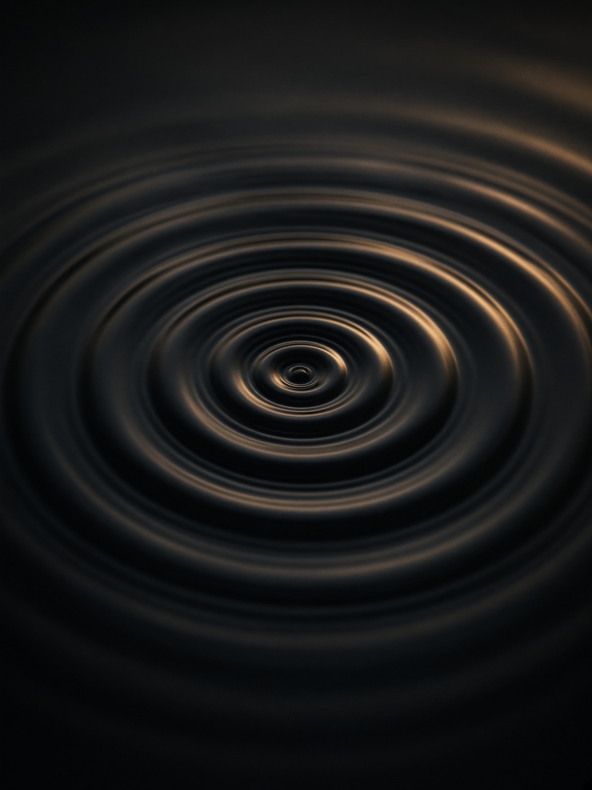 Black water in concentric cymatic ripples with a brass highlight.
